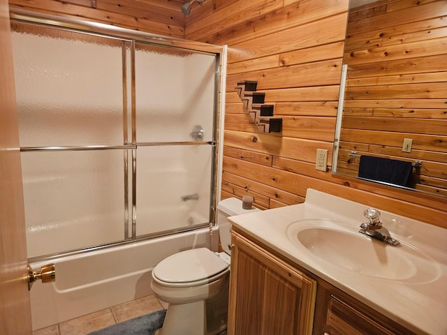 full bathroom with tile patterned flooring, enclosed tub / shower combo, toilet, and wood walls