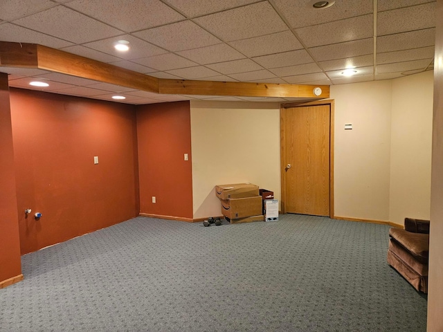 basement featuring a paneled ceiling and carpet