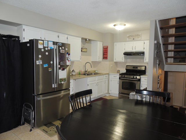 kitchen featuring appliances with stainless steel finishes, a textured ceiling, white cabinetry, and sink