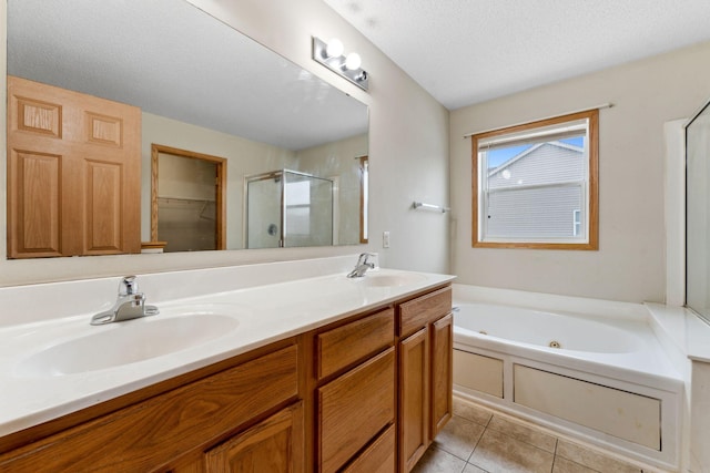 bathroom featuring tile patterned flooring, vanity, a textured ceiling, and separate shower and tub