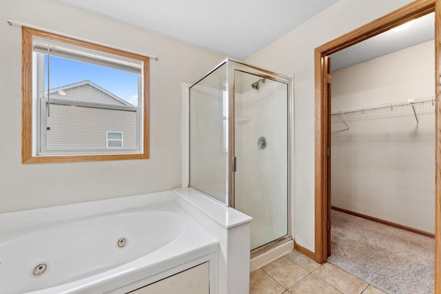 bathroom with tile patterned flooring, shower with separate bathtub, and a textured ceiling