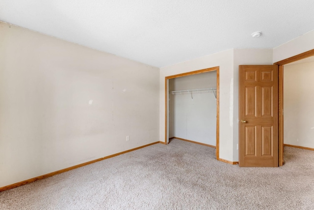 unfurnished bedroom with light colored carpet and a closet