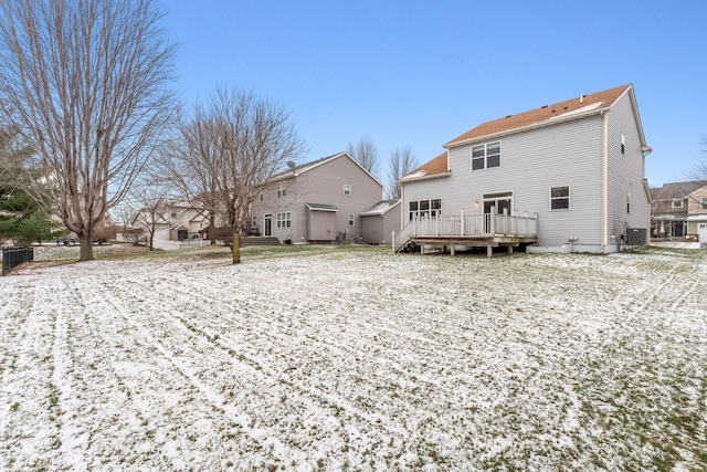 snow covered back of property featuring cooling unit and a wooden deck