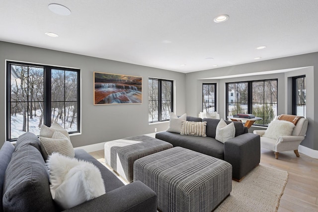 living area featuring recessed lighting, baseboards, and light wood-type flooring