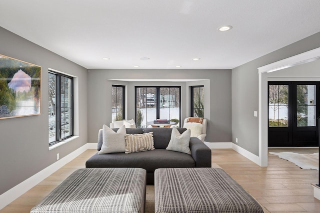 living area featuring recessed lighting, french doors, baseboards, and light wood-style floors