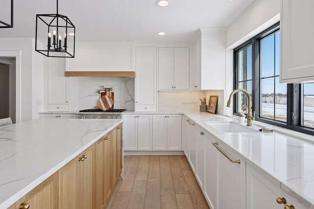 kitchen featuring recessed lighting, light wood-style floors, tasteful backsplash, and a sink