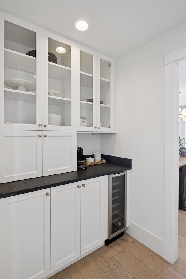 bar with recessed lighting, beverage cooler, light wood-type flooring, and baseboards