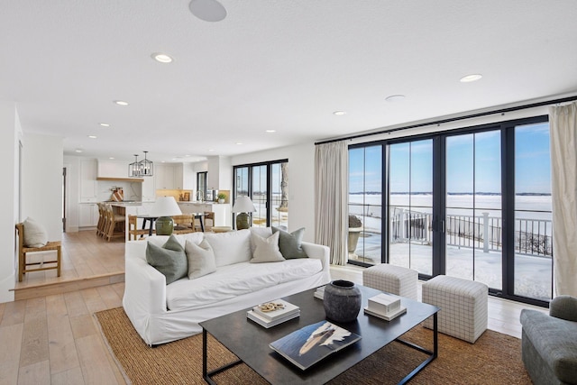 living area with recessed lighting, french doors, and light wood-style floors