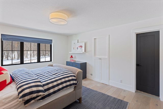 bedroom featuring light wood-type flooring and baseboards