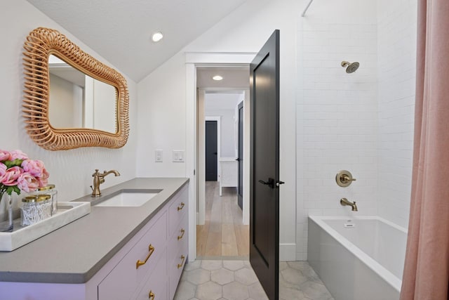 bathroom with vanity, shower / washtub combination, tile patterned flooring, vaulted ceiling, and a textured ceiling