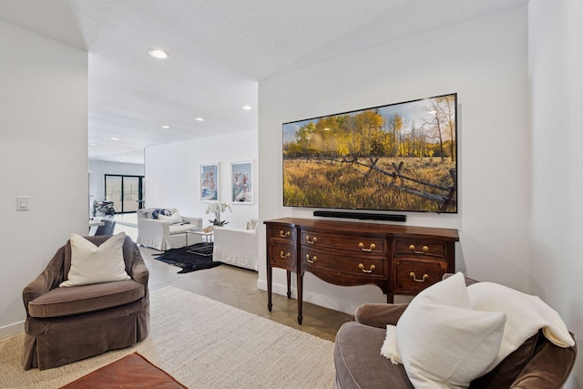 living area with a textured ceiling, recessed lighting, baseboards, and finished concrete floors