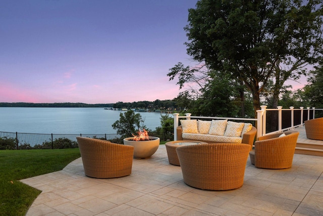 view of patio featuring a water view, fence, and an outdoor fire pit