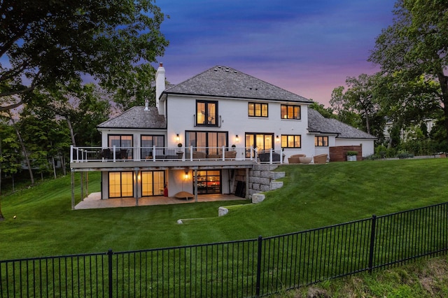 rear view of property with a wooden deck, a yard, a fenced backyard, a chimney, and a patio area