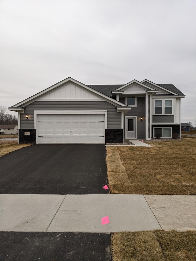 view of front of home with a front yard and a garage