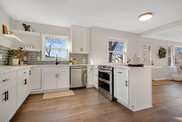 kitchen featuring plenty of natural light, white cabinets, stainless steel appliances, and dark hardwood / wood-style floors