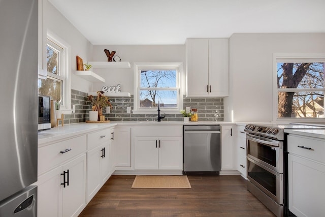 kitchen with white cabinetry, sink, dark wood-type flooring, stainless steel appliances, and backsplash