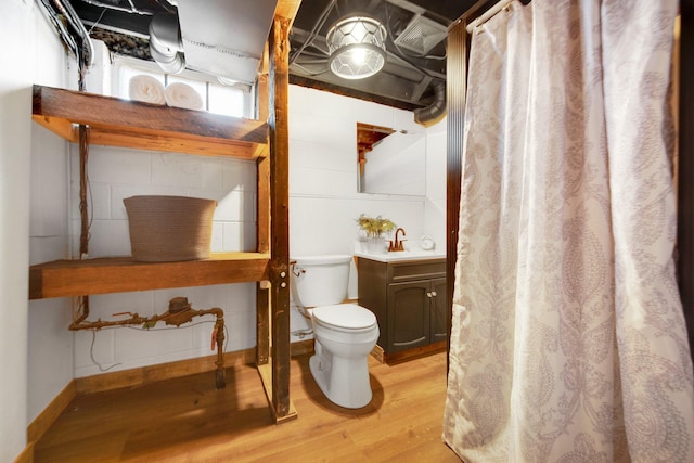 bathroom with wood-type flooring, vanity, and toilet