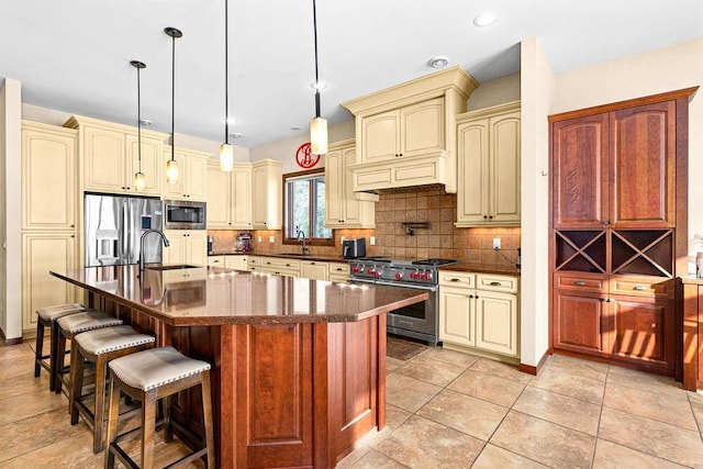 kitchen with stainless steel appliances, cream cabinets, a sink, and decorative backsplash