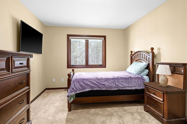 bedroom featuring baseboards and light colored carpet