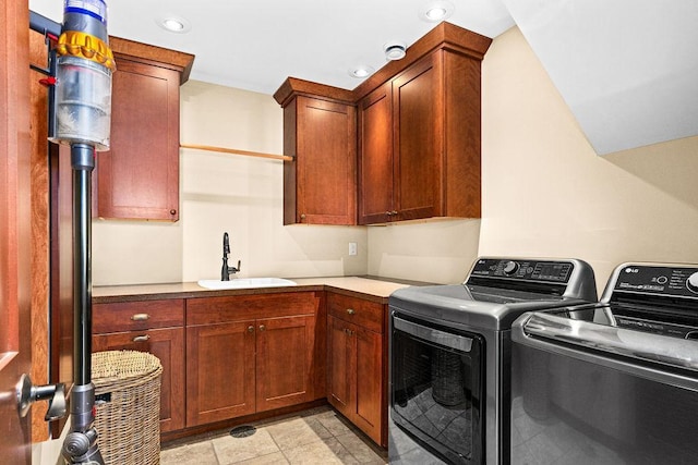 laundry room with cabinet space, washing machine and dryer, and a sink