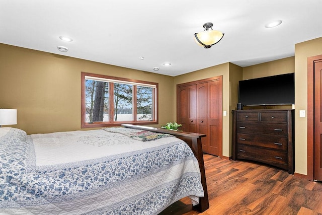 bedroom with baseboards, dark wood finished floors, a closet, and recessed lighting