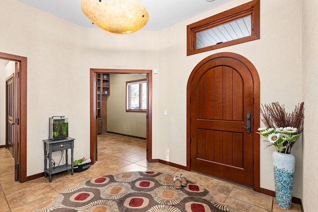 entryway with arched walkways and baseboards