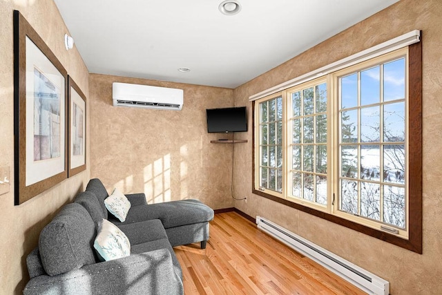 sitting room with a baseboard heating unit, a wall unit AC, wood finished floors, and recessed lighting