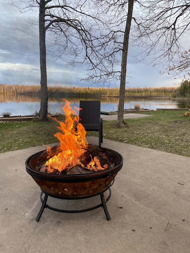 view of patio / terrace featuring an outdoor fire pit and a water view