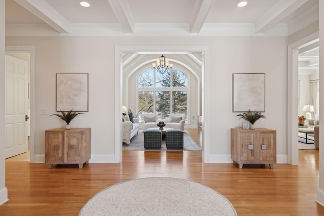 living area featuring beamed ceiling, ornamental molding, a chandelier, and hardwood / wood-style flooring