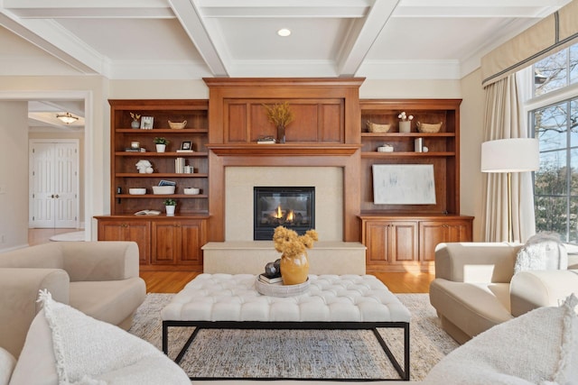 living room with coffered ceiling, beam ceiling, light hardwood / wood-style floors, and a premium fireplace