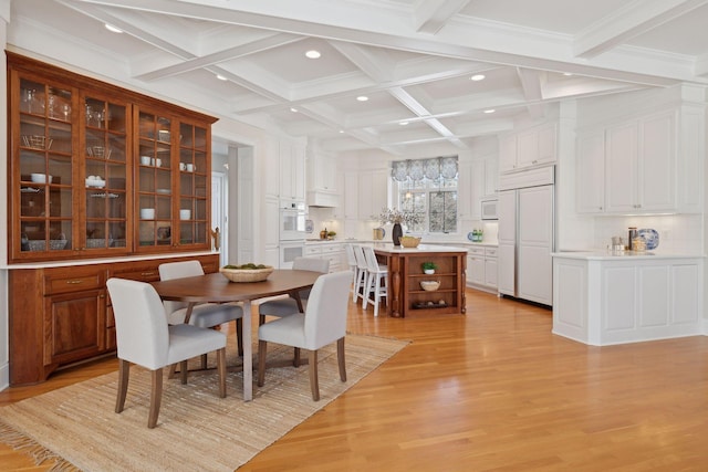 dining space featuring coffered ceiling, beam ceiling, and light wood-type flooring