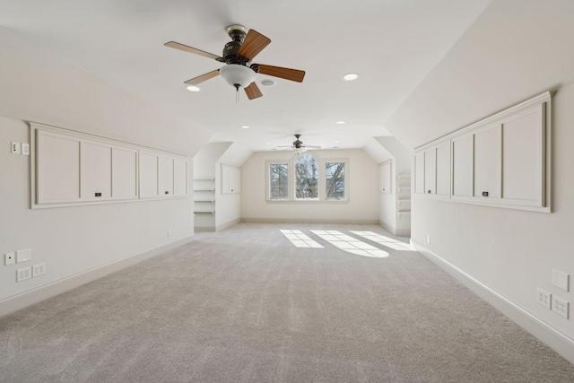 bonus room with lofted ceiling, built in features, and light colored carpet