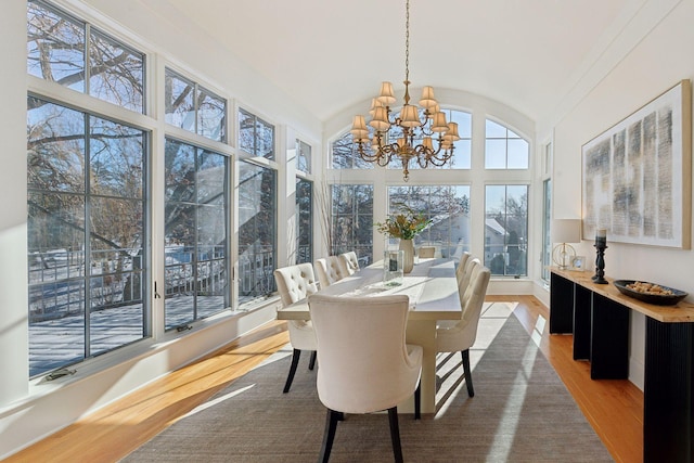 sunroom / solarium featuring a chandelier and vaulted ceiling