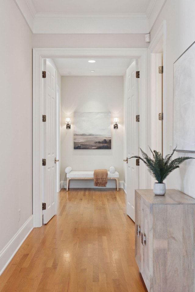 corridor featuring ornamental molding and light wood-type flooring