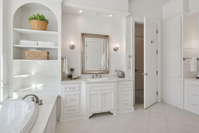 bathroom with vanity, a relaxing tiled tub, and tile patterned floors