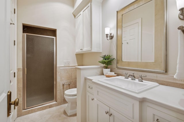 bathroom featuring vanity, toilet, tile walls, and a shower with shower door