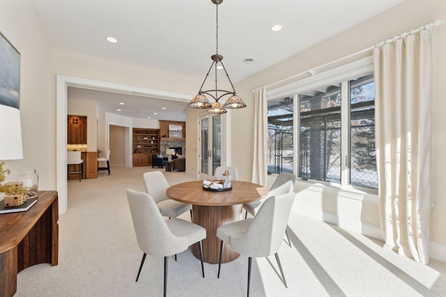 dining room with light colored carpet and a notable chandelier