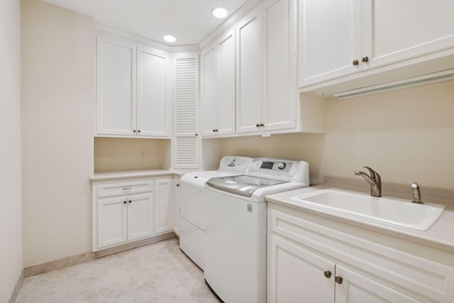 laundry room with sink, light tile patterned floors, washing machine and dryer, and cabinets