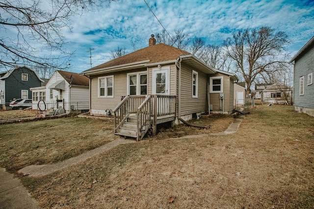 rear view of property featuring a yard