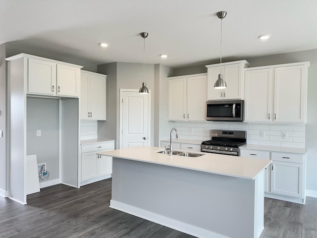 kitchen with white cabinetry, sink, stainless steel appliances, dark hardwood / wood-style floors, and decorative light fixtures