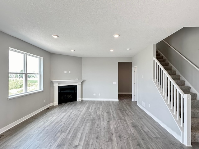 unfurnished living room with a textured ceiling and hardwood / wood-style flooring