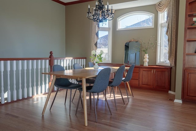 dining space with light wood-style floors, a towering ceiling, and a notable chandelier