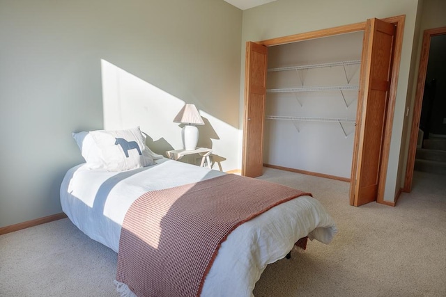 carpeted bedroom featuring baseboards and a closet