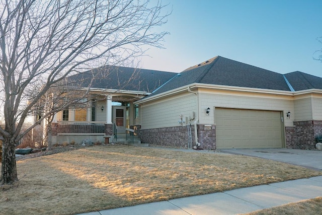 ranch-style home featuring a porch, an attached garage, brick siding, a shingled roof, and driveway