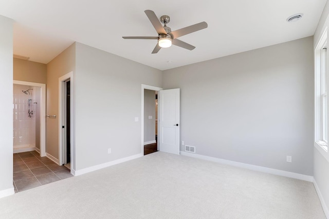 unfurnished bedroom with light carpet, ensuite bath, and ceiling fan