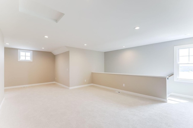 basement featuring plenty of natural light and light colored carpet