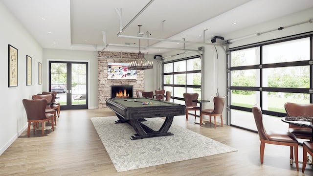 rec room featuring a fireplace, french doors, light wood-type flooring, and billiards