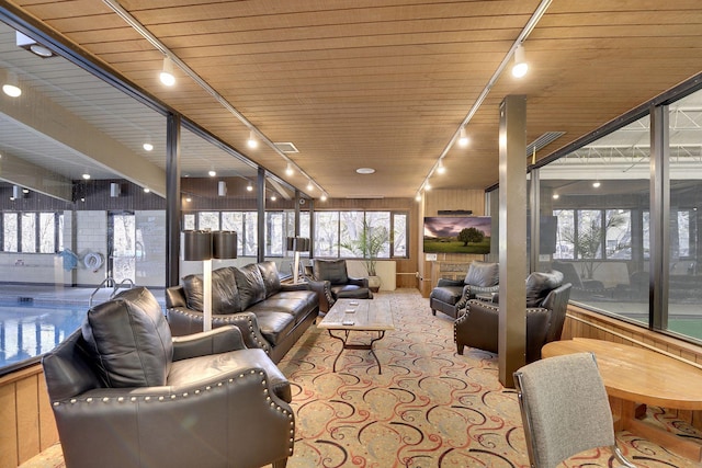 living room featuring rail lighting and wood ceiling