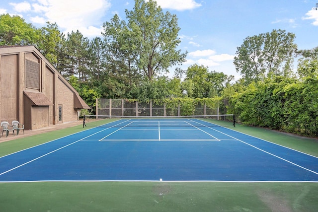 view of tennis court with community basketball court and fence