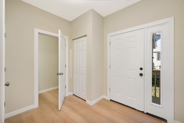 foyer entrance with a wealth of natural light and light hardwood / wood-style flooring